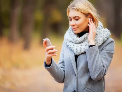 Young Beauty woman listening music in autumn forest - Фото, изображение
