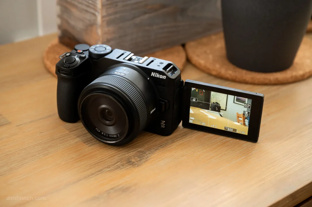 Nikon Z30 із фіксом NIKKOR Z 28mm f/2.8 на дерев'яному столі, поворотний екран розгорнуто вперед