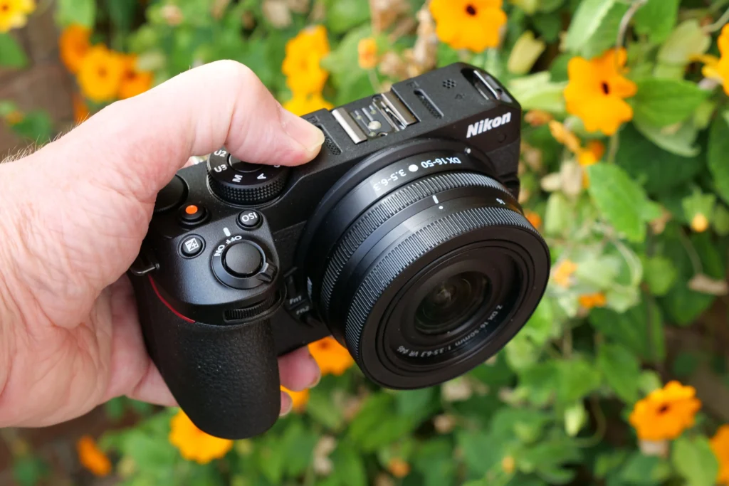 Nikon Z30 із китовим зумом Z DX 16-50mm f/3.5-6.3 VR у руці, добре видно глибокий хват корпусу