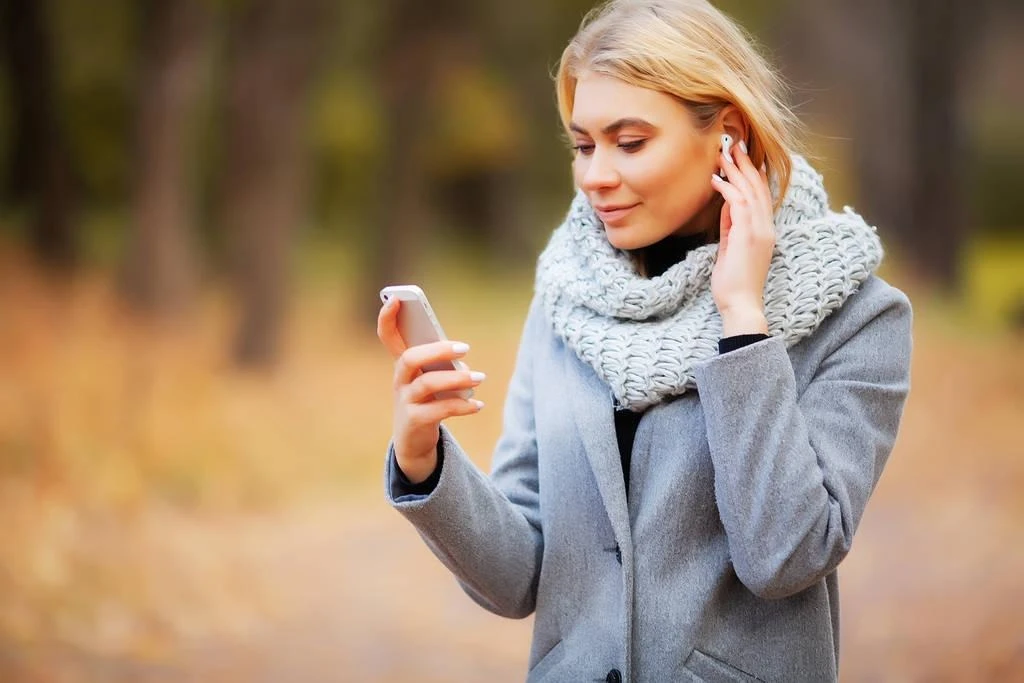 Young Beauty woman listening music in autumn forest - Фото, изображение